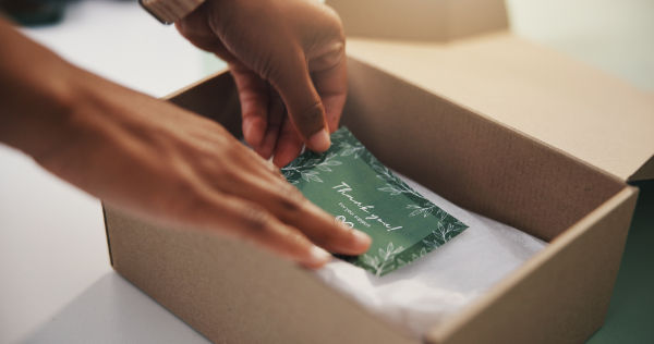 Handwritten thank-you note tucked into a branded gift box
